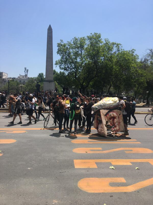 Manifestantes  y cabeza gigante en Avenida Providencia