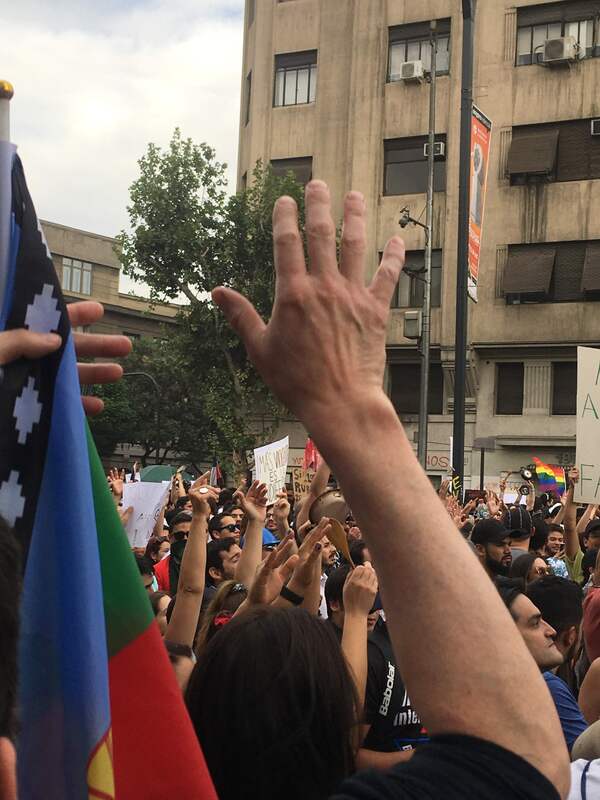 Manifestantes levantando los brazos